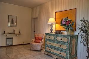 a room with a dresser with a lamp and a chair at Casa da Palmeira, pool & soccer pitch in Vilamoura