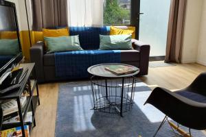 ein Wohnzimmer mit einem blauen Sofa und einem Tisch in der Unterkunft La verrière sur cour #L6 in Grenoble