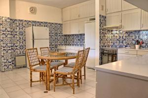 a kitchen with a table and chairs and a refrigerator at Casa da Palmeira, pool & soccer pitch in Vilamoura