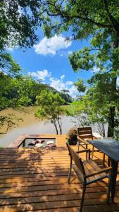 a wooden deck with two benches and a table at Arau Cabana Cheiro de Mato in Flores da Cunha