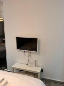um quarto com uma televisão numa parede branca em Small budget diamond apartment in Agias Sofias. em Tessalônica