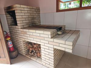 um forno de tijolos com lareira numa cozinha em LarDoceFesta Home em Pedra Azul