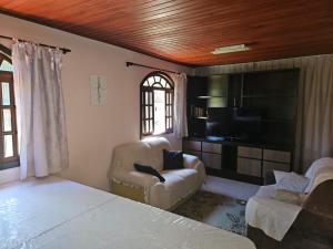 ペドラ・アズールにあるLarDoceFesta Homeのリビングルーム(ベッド1台、ソファ、テレビ付)