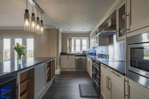 a large kitchen with stainless steel appliances and counters at The Homestead by Bloom Stays in Canterbury