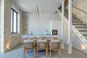 un comedor con mesa y sillas y una escalera en Perla Dream Luxury Villa, en La Canea