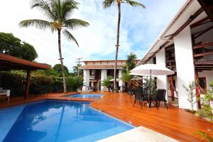 een villa met een zwembad en palmbomen bij Flamingo Beach - Rede Soberano in Porto Seguro
