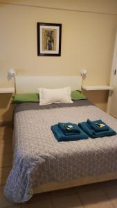 Una cama con dos toallas azules encima. en Excelente monoambiente completo, funcional y muy cómodo - Zona "Aldrey" en Mar del Plata