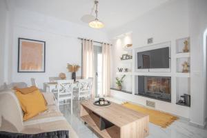 Μοντέρνο διαμέρισμα ALMYRA في آغيوس نيكولاوس: غرفة معيشة بيضاء مع أريكة وطاولة