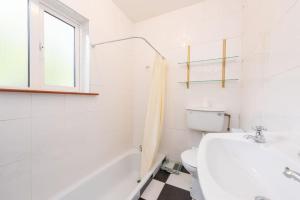 Baño blanco con lavabo y aseo en Tai Chi House, T Dempsey's house en Waterford