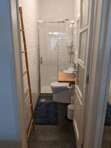 a bathroom with a toilet and a glass shower door at the light house in Vila Real de Santo António