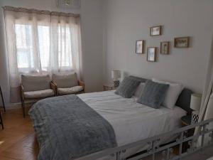a bedroom with a large bed and two chairs at the light house in Vila Real de Santo António