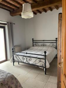 een slaapkamer met een bed met een zwart metalen frame bij Villa with pool Trasimeno in Panicale