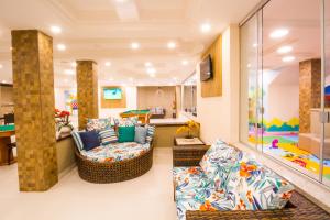 a living room with two couches and a kitchen at Portal Ville - Rede Soberano in Porto Seguro