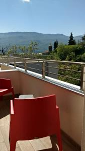 una sedia rossa su un balcone con vista di TopFloor Ohrid a Ohrid