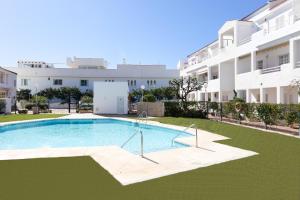una piscina vacía frente a un edificio en El Castillo del Sol, en Fuengirola