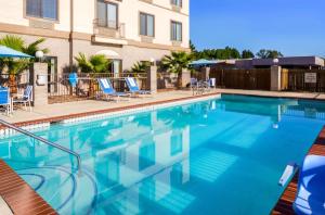 una grande piscina con sedie blu e un edificio di Americas Best Value Inn & Suites-Livingston a Livingston