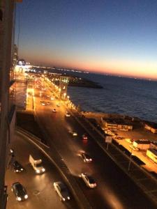 een weg met auto's geparkeerd op het naast de oceaan bij ستانلي اسكندريه in Alexandrië