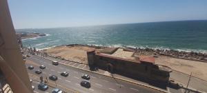 een uitzicht op de oceaan en een weg met auto's bij ستانلي اسكندريه in Alexandrië