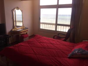 een slaapkamer met een bed, een spiegel en een raam bij ستانلي اسكندريه in Alexandrië