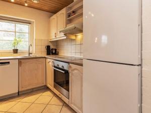 eine Küche mit einem weißen Kühlschrank und einem Fenster in der Unterkunft 12 person holiday home in V ggerl se in Bøtø By