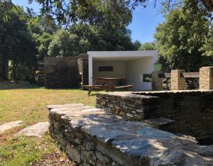 a building with a stone wall in a yard at Chambres d’hôtes A Casa Di Marigaby in Barbaggio