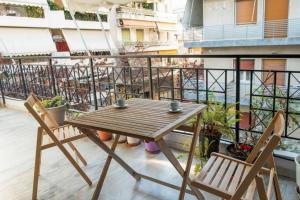 d'une table en bois et de deux chaises sur un balcon. dans l'établissement Apartment in Athens, Pagrati, à Athènes