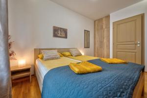 een slaapkamer met een groot bed met gele kussens erop bij Apartman Montis Zlatibor in Zlatibor