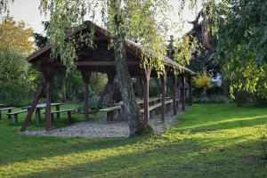 um pavilhão de madeira num parque com uma árvore em Domek 1 w Rancho Żnin em Znin