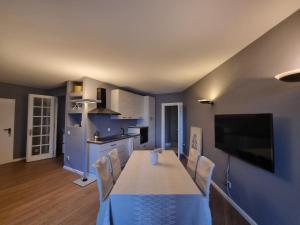 eine Küche mit einem Tisch und Stühlen sowie einem TV in der Unterkunft Lake Apartment 3 in Bissone