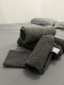 una pila de toallas y almohadas en una cama en Mini duplex moderno bien ubicado., en Tarifa