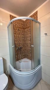 a glass shower in a bathroom with a toilet at Apartament DoDe Predeal in Predeal +3 photos