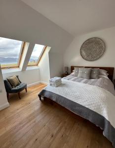 a bedroom with a large bed and two windows at Sealladh in Port Appin