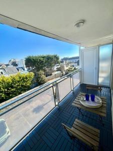 a balcony with a table and chairs on a balcony at Plage, piscine, terrasse & centre-ville à Quiberon in Quiberon