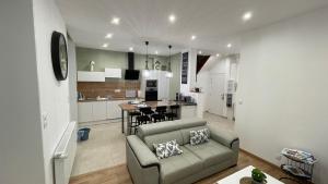 een woonkamer met een bank en een keuken bij Au jardin de la Basilique in Boulogne-sur-Mer