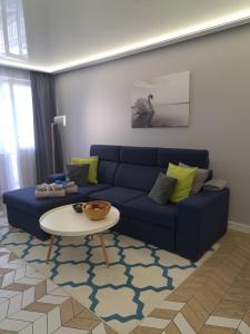 a living room with a blue couch and a table at Apartament Augustów SWAN in Augustów