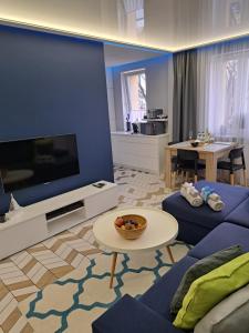 salon z dużym telewizorem i kanapą w obiekcie Apartament Augustów SWAN w mieście Augustów
