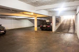a parking garage with two cars parked in it at Hotel Montana Aeroporto in Brasilia