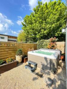 a hot tub sitting in a yard next to a fence at Logement entier avec jacuzzi en provence in Le Thor