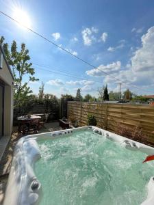 a large hot tub in a backyard with a fence at Logement entier avec jacuzzi en provence in Le Thor