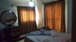 a bedroom with a bed with a mirror and curtains at ستانلي اسكندريه in Alexandria
