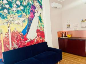 un salon avec un canapé bleu devant un tableau dans l'établissement ConteMax ArtHouse, à Salerne