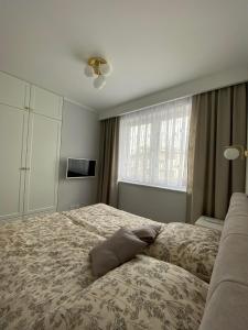 a bedroom with a large bed and a window at Apartamenty Klifowa Rewal - Strefa Rekreacji in Rewal