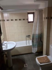 La salle de bains est pourvue d'une baignoire, d'un lavabo et de toilettes. dans l'établissement Saint George, à Kalavrita