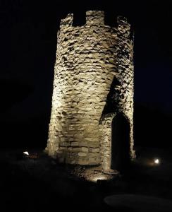 an old stone tower at night with lights on it at La Choza De Mamuyo in Montefrío