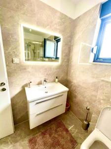 a bathroom with a white sink and a mirror at Apartment Aron in Biograd na Moru