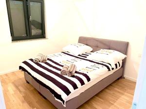 a bed with black and white striped sheets and pillows at Apartment Aron in Biograd na Moru