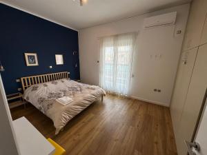 1 dormitorio con cama y pared azul en Vasilis luxury apartment en Athens