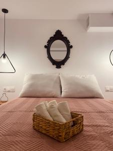 a bedroom with a basket with towels on a bed at Galanos Katoikies in Órmos Aiyialís