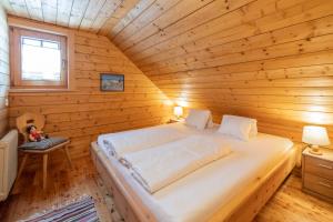a bedroom with a bed in a wooden cabin at Zirbenhütte am Falkert auf der Heidi-Alm in Koflach