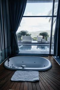 a bath tub in a room with a large window at BigPool - Diamond Mansion in Had Nes